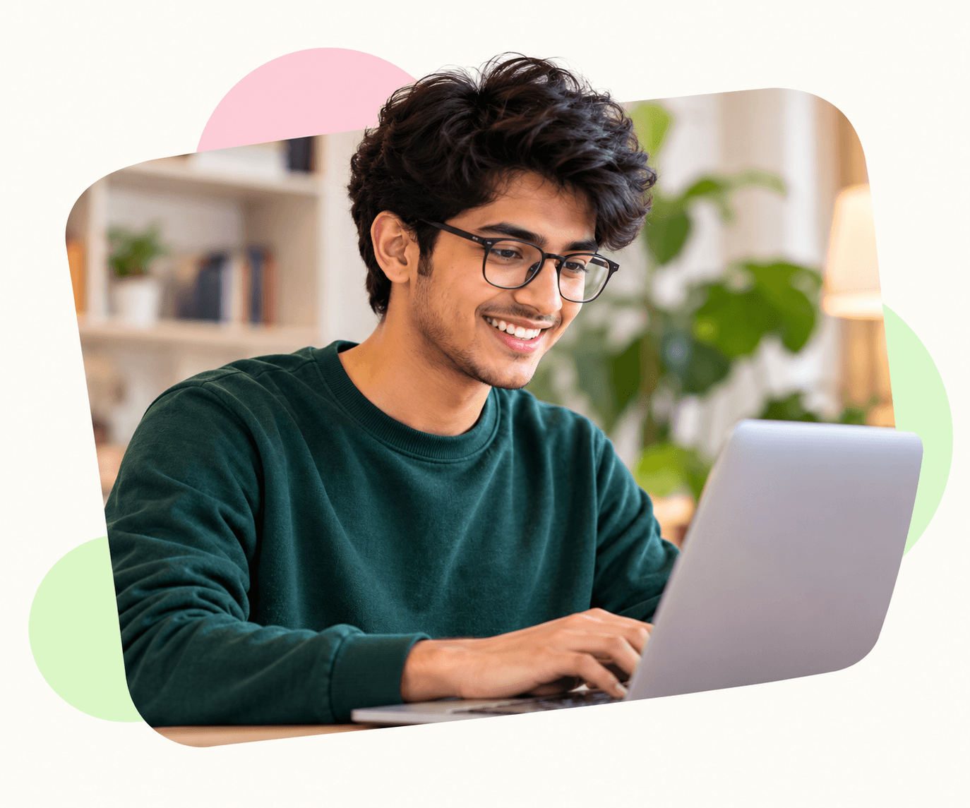 Student with glasses smiling at his laptop