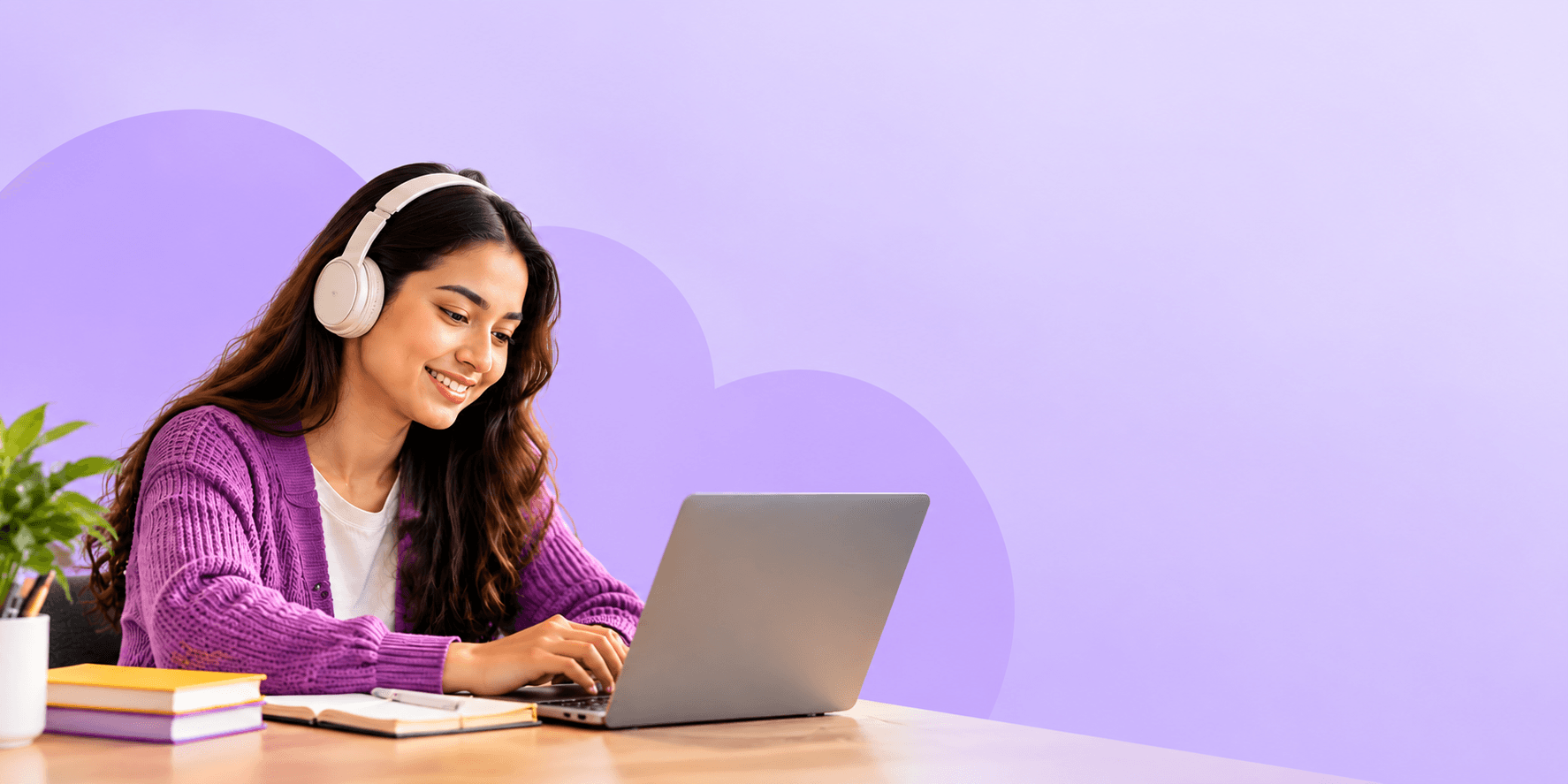 Learner wearing headphones studying on her laptop